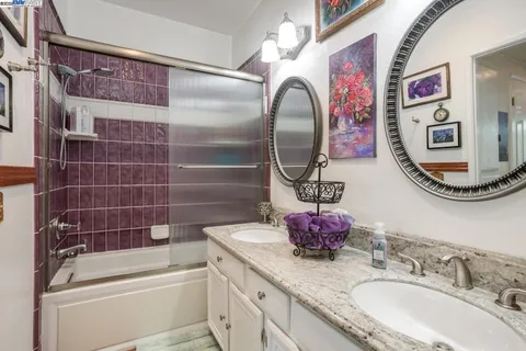 a bathroom with a granite countertop bathtub sink vanity and mirror