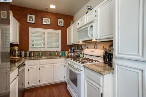 a kitchen with stainless steel appliances granite countertop a stove and a sink