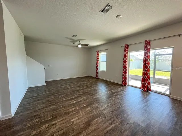 an empty room with wooden floor and window