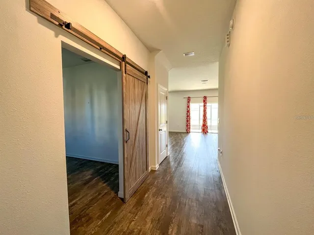 a view of a hallway with wooden floor
