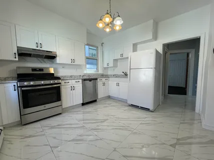 a kitchen with a refrigerator a sink dishwasher and wooden floor