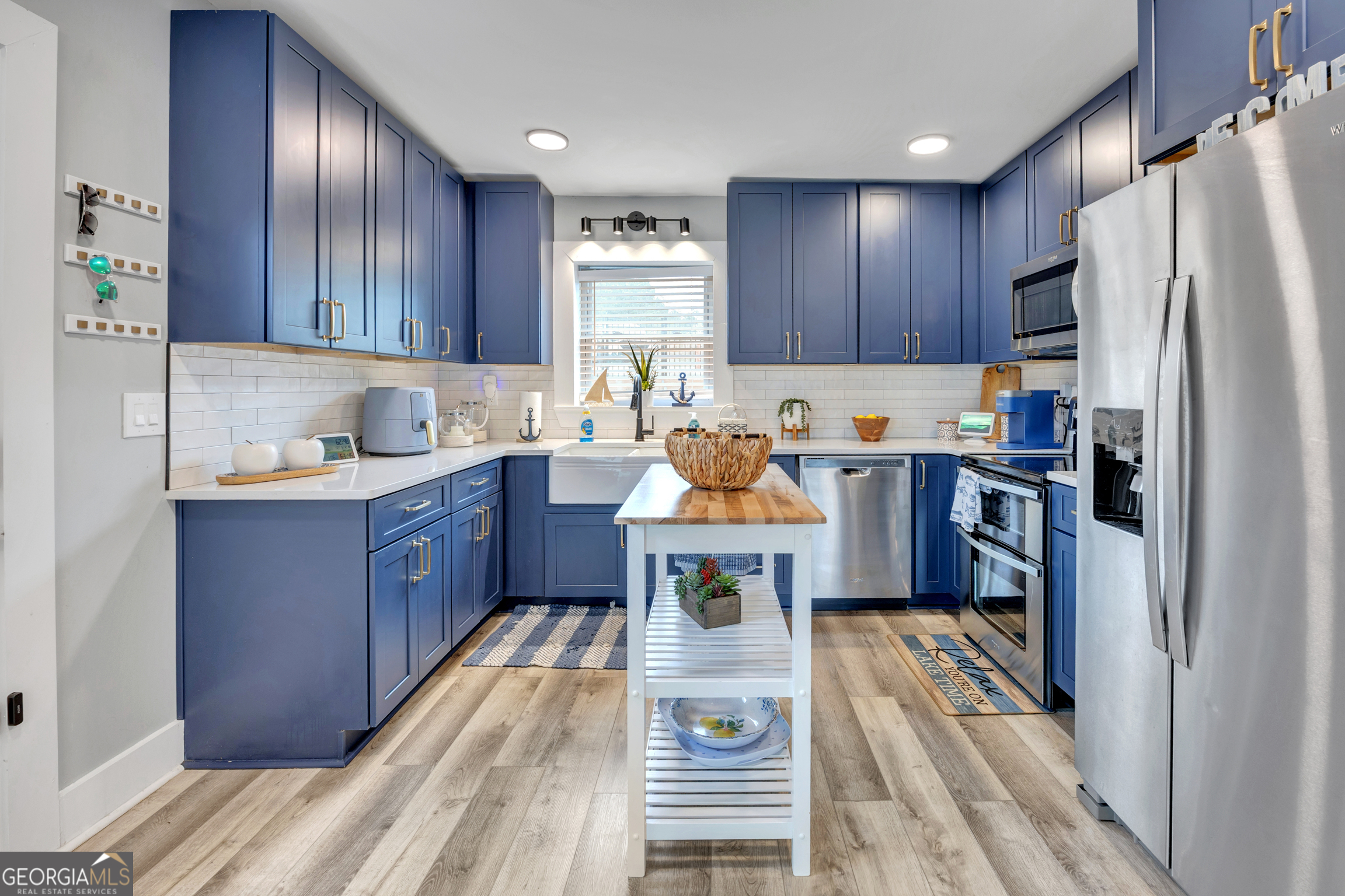 8900 Jackson Lake Road Monticello, GA 31064 - Photo 34 of 72 a kitchen with a refrigerator a stove top oven a sink dishwasher and wooden cabinets