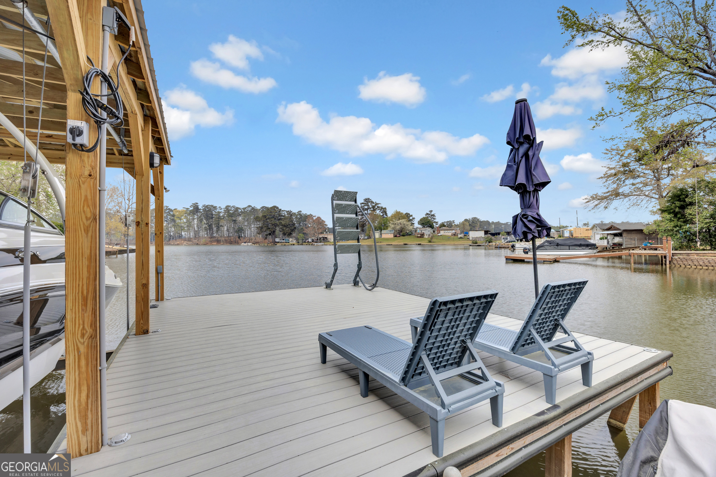 8900 Jackson Lake Road Monticello, GA 31064 - Photo 59 of 72 a view of a lake with couches chairs and wooden floor