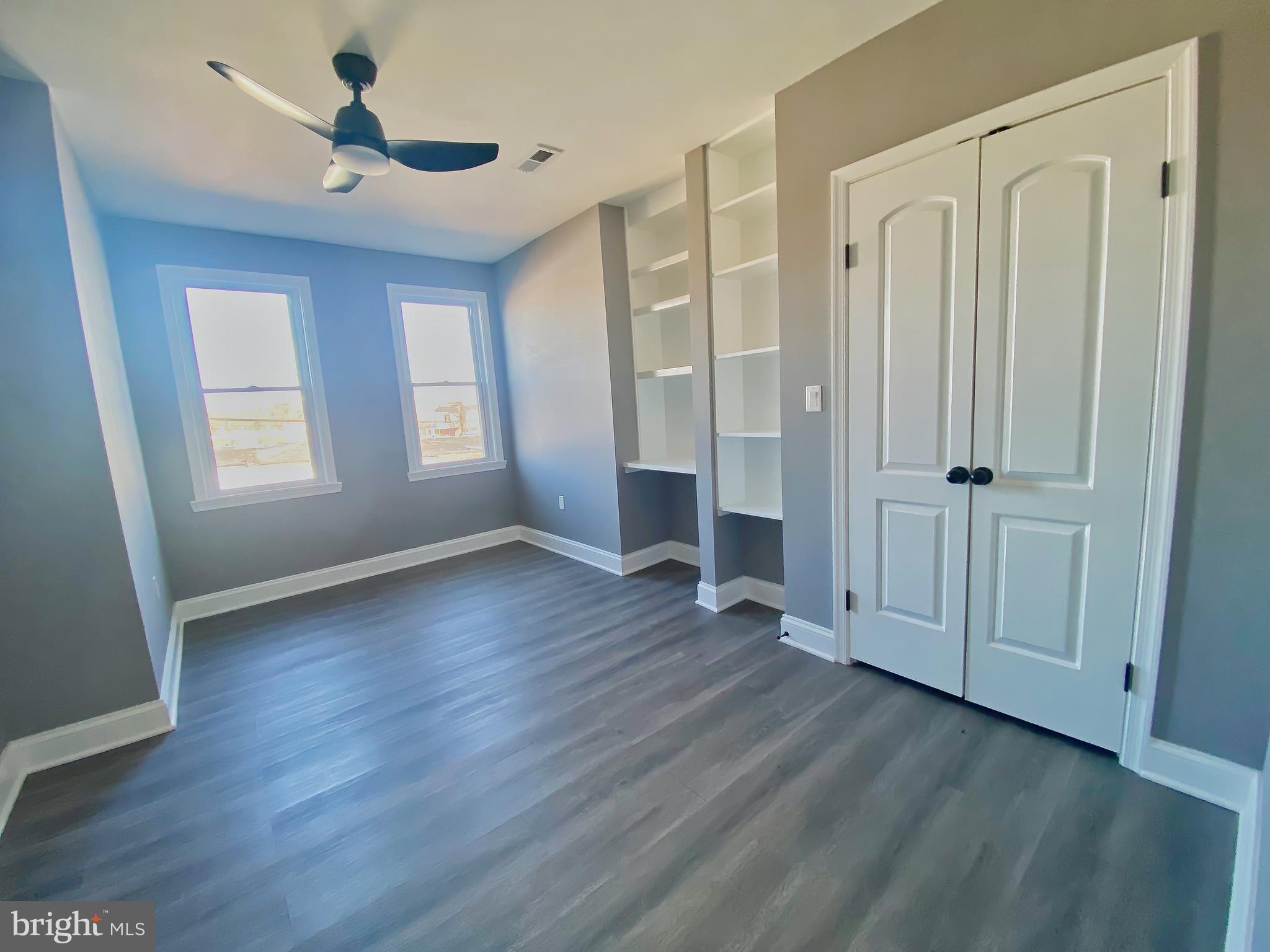 1604 Cliftview Avenue Baltimore, MD 21213 - Photo 21 of 36 an empty room with wooden floor and windows