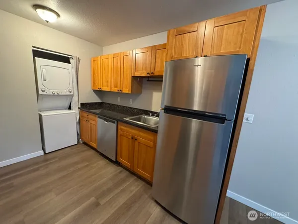 a kitchen with a refrigerator sink and cabinets