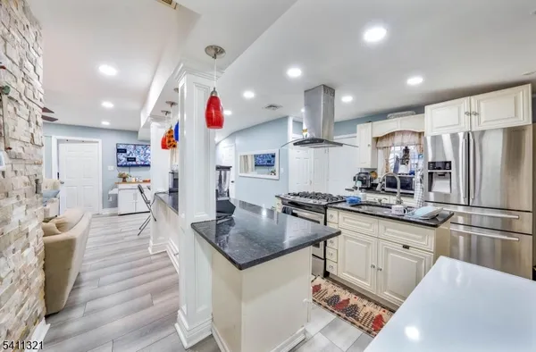 a kitchen with stainless steel appliances granite countertop a sink refrigerator and cabinets
