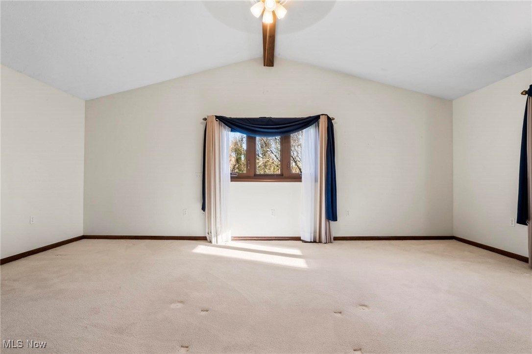 3290 State Rte 534 Geneva, OH 44041 - Photo 19 of 43 Empty room featuring ceiling fan, light carpet, and lofted ceiling with beams