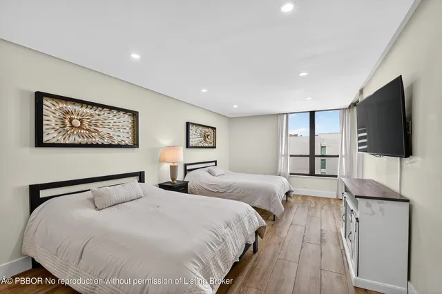 a bedroom with two large bed and a flat screen tv