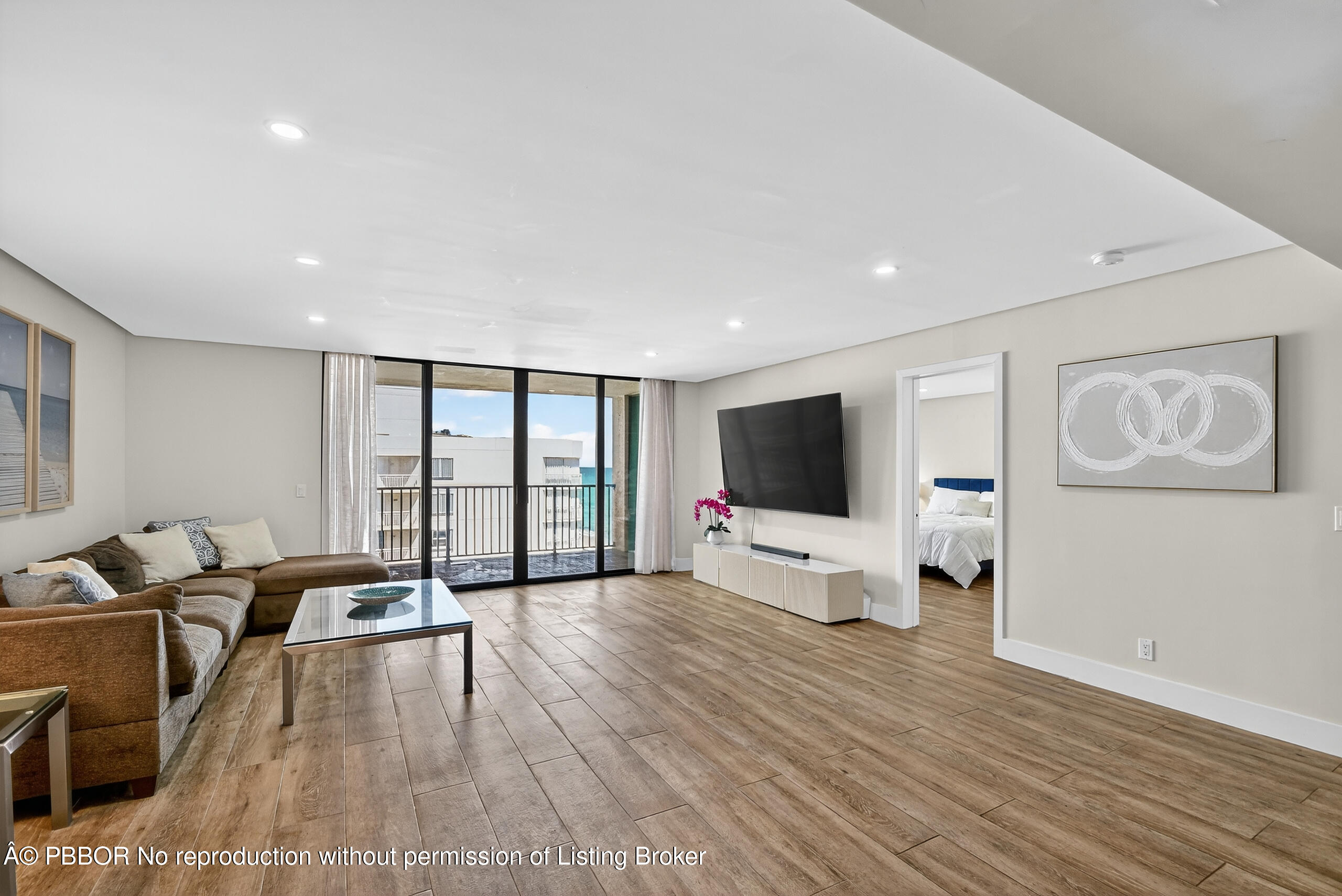 3610 South Ocean Boulevard, Unit 608 Palm Beach, FL 33480 - Photo 7 of 38 a living room with furniture a flat screen tv and a floor to ceiling window