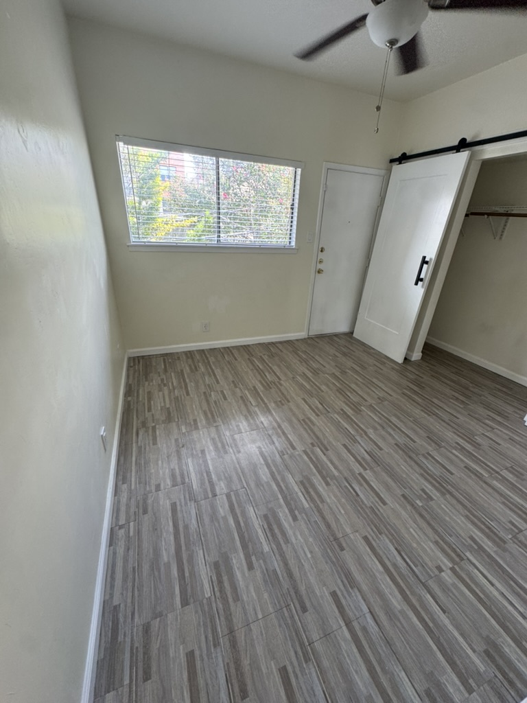 3000 Guadalupe Street, Unit 214 Austin, TX 78705 - Photo 2 of 7 an empty room with wooden floor and windows