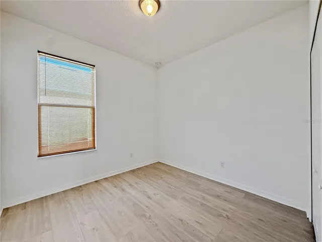 an empty room with a window and wooden floor