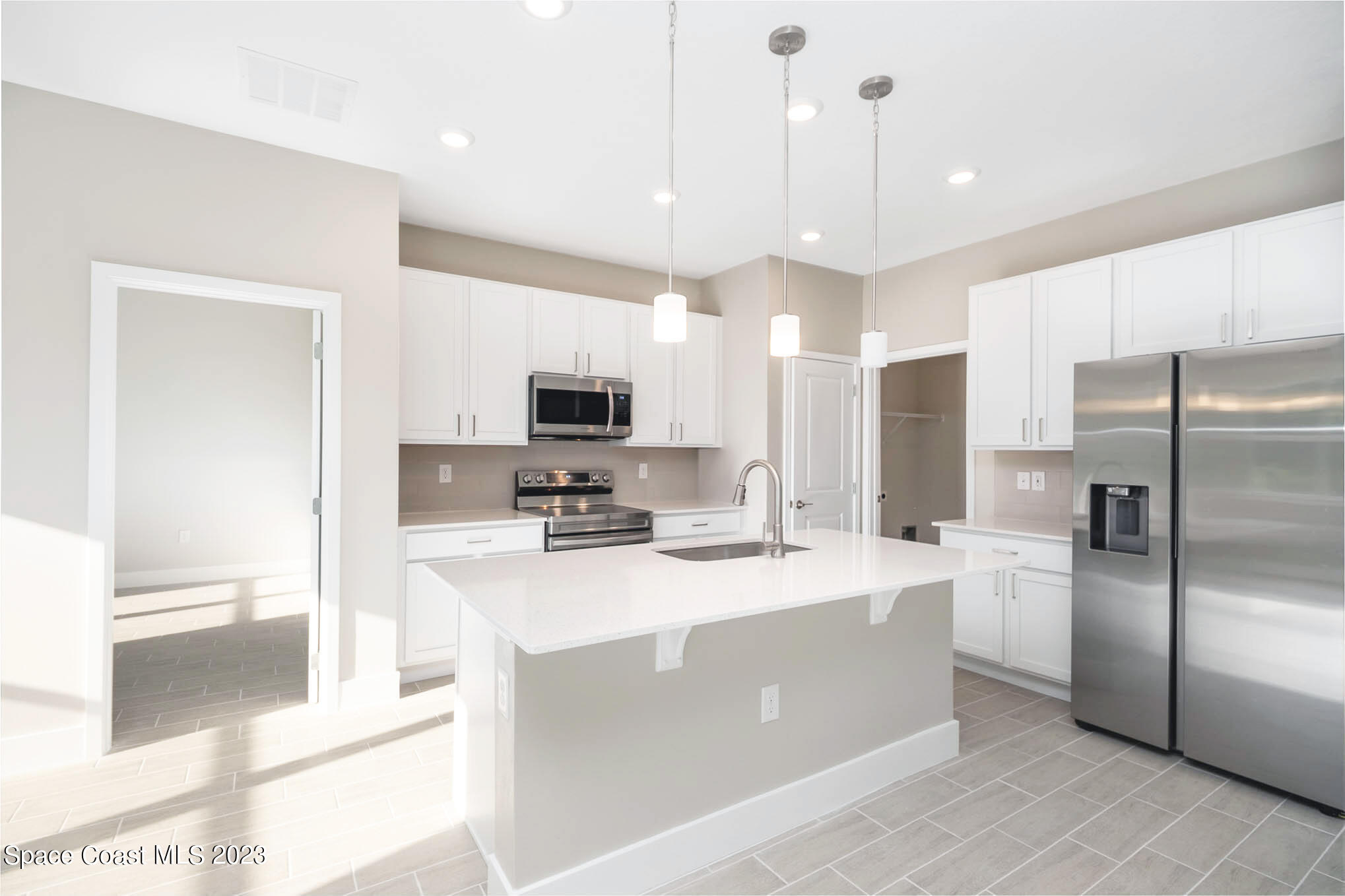 365 Wendover Road Southwest Palm Bay, FL 32908 - Photo 7 of 21 a kitchen with stainless steel appliances a refrigerator sink and microwave