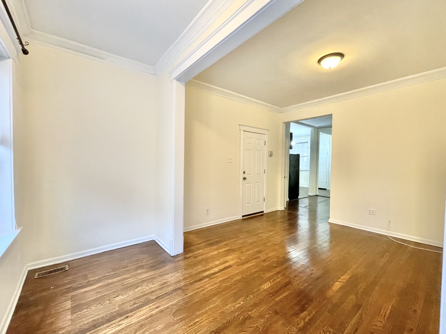 4349 North Spaulding Avenue, Unit 1 Chicago, IL 60618 - Photo 5 of 18 a view of an empty room with wooden floor and a window