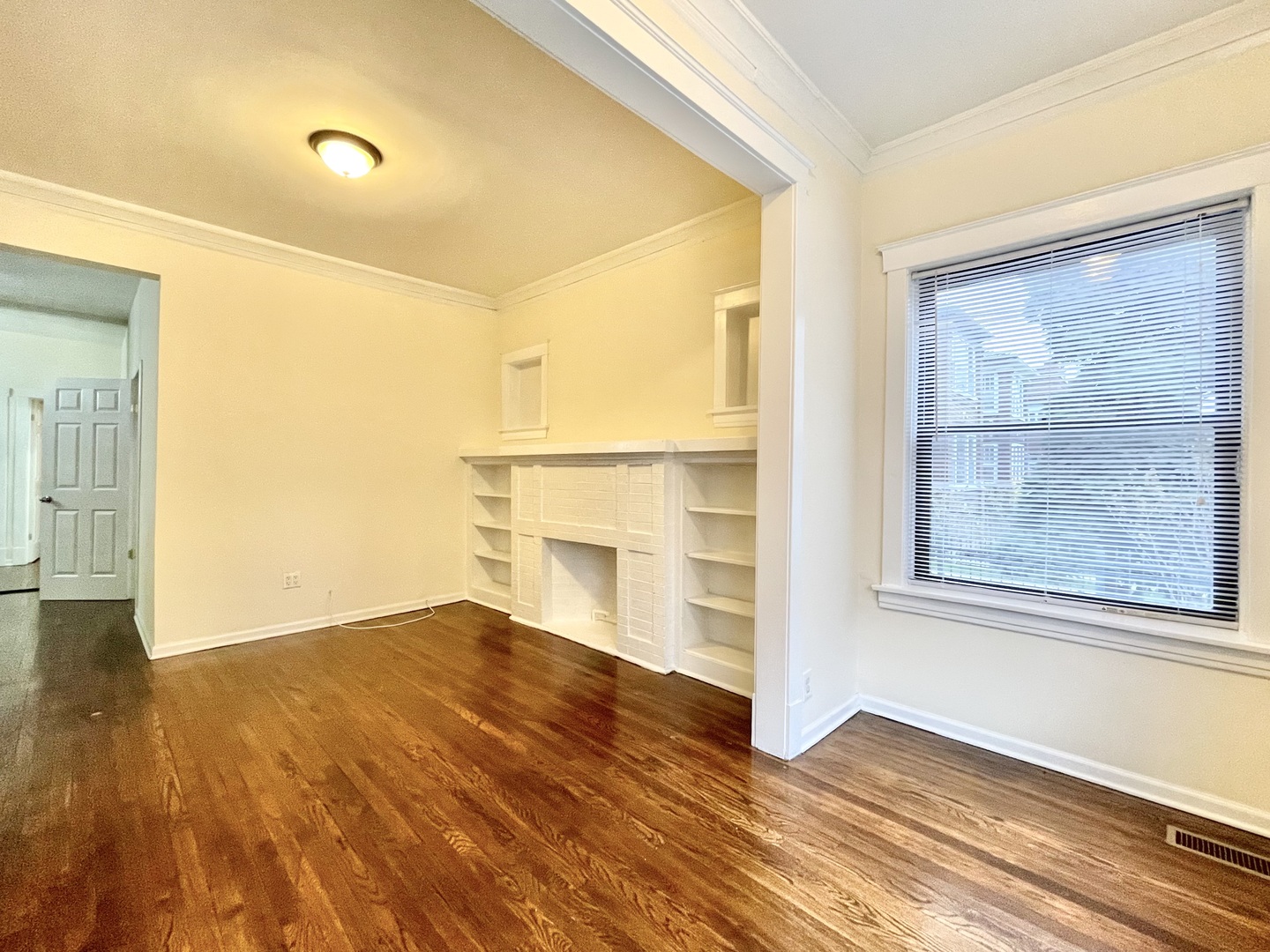 4349 North Spaulding Avenue, Unit 1 Chicago, IL 60618 - Photo 6 of 18 a view of an empty room with wooden floor and a window
