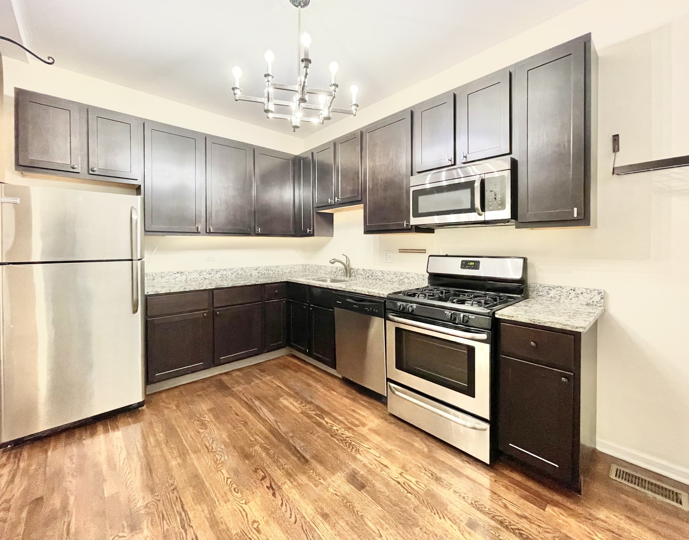 4349 North Spaulding Avenue, Unit 1 Chicago, IL 60618 - Photo 8 of 18 a kitchen with granite countertop stainless steel appliances and wooden cabinets