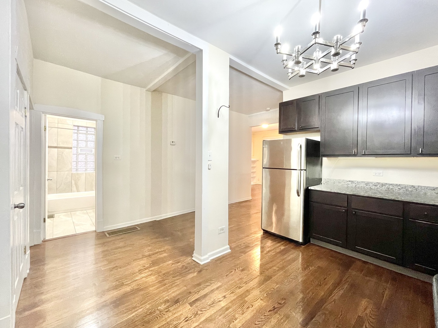 4349 North Spaulding Avenue, Unit 1 Chicago, IL 60618 - Photo 9 of 18 a view of a kitchen with wooden floor and a refrigerator