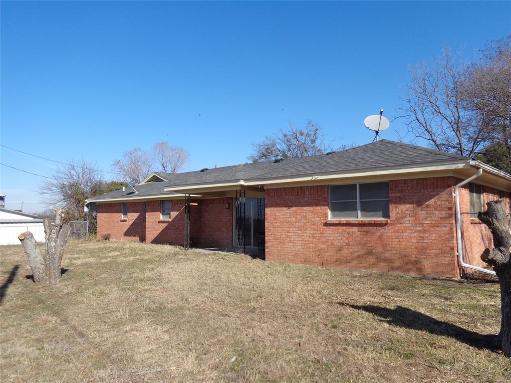 612 South Files Street Itasca, TX 76055 - Photo 26 of 30 Rear view of house featuring a lawn, brick siding, and roof with shingles
