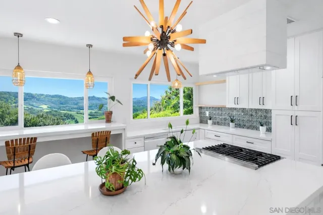 a kitchen with a sink a counter and chairs
