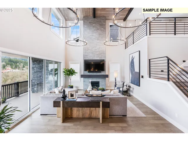 a living room with couches a fireplace and a dining table with wooden floor