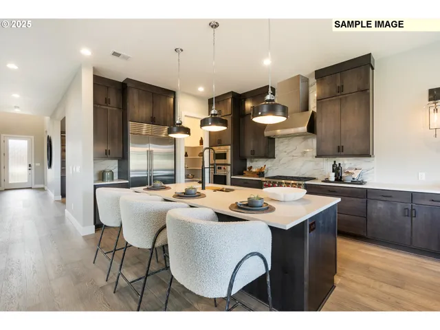 a kitchen with stainless steel appliances kitchen island granite countertop a sink a stove a dining table and chairs