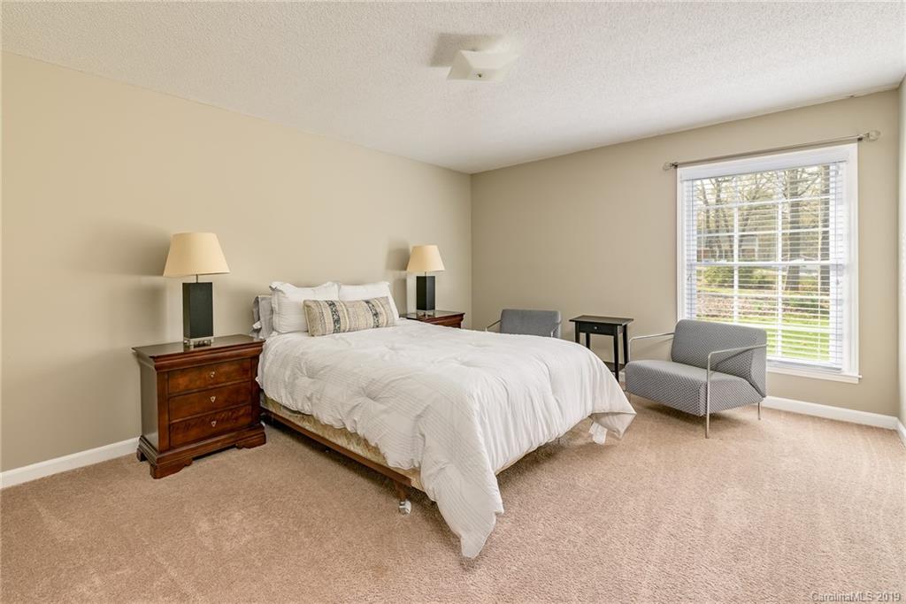 3224 Allenwood Road Charlotte, NC 28270 - Photo 17 of 38 a spacious bedroom with a bed and a couch next to a window