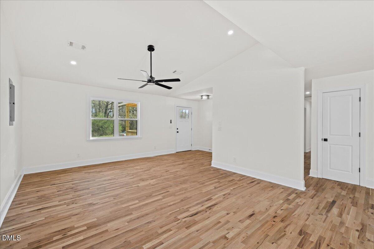 598 Bentonville Road Four Oaks, NC 27524 - Photo 12 of 40 an empty room with wooden floor ceiling fan and windows