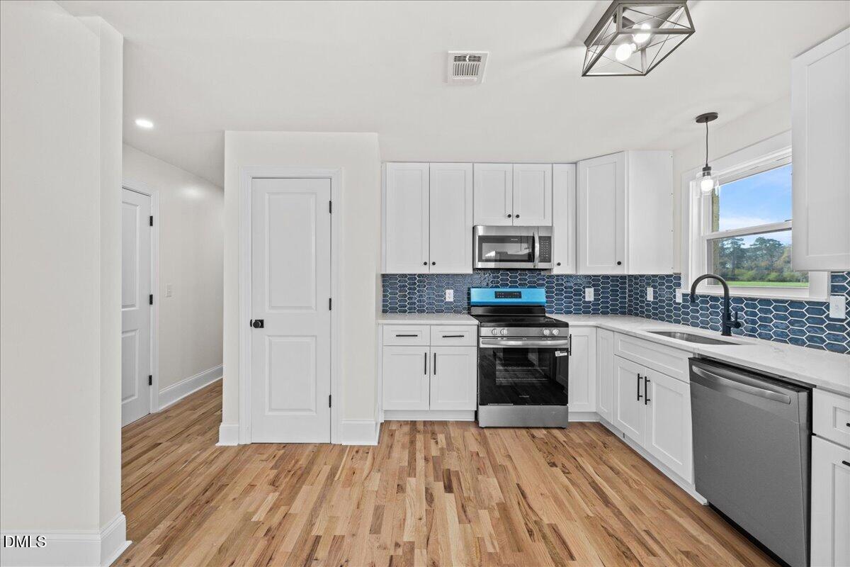 598 Bentonville Road Four Oaks, NC 27524 - Photo 15 of 40 a kitchen with cabinets oven and a dishwasher