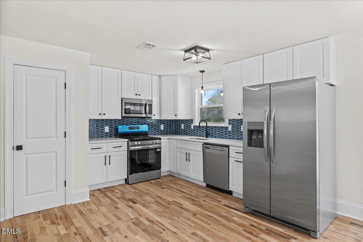 598 Bentonville Road Four Oaks, NC 27524 - Photo 16 of 40 a kitchen with a refrigerator stove and sink