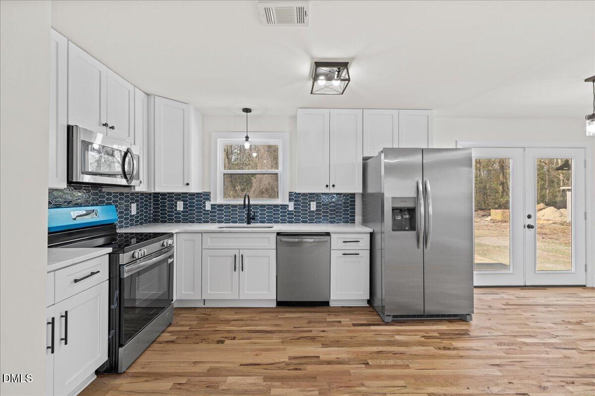 598 Bentonville Road Four Oaks, NC 27524 - Photo 17 of 40 a kitchen with stainless steel appliances granite countertop a refrigerator a stove and white cabinets