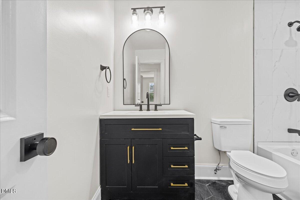 598 Bentonville Road Four Oaks, NC 27524 - Photo 22 of 40 a bathroom with a toilet a sink and mirror