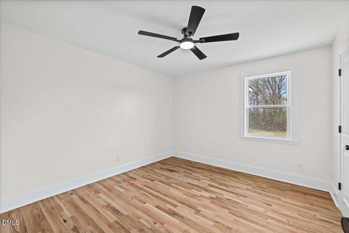 598 Bentonville Road Four Oaks, NC 27524 - Photo 24 of 40 a view of a room with wooden floor and a ceiling fan