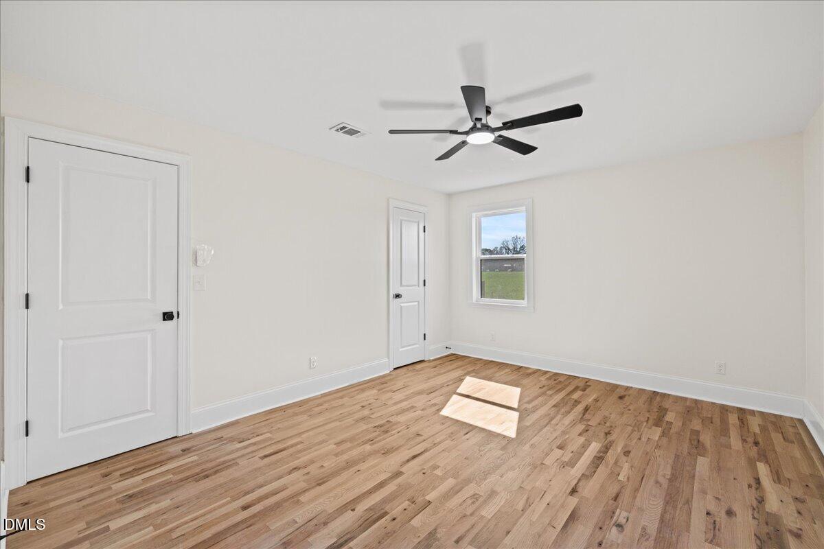 598 Bentonville Road Four Oaks, NC 27524 - Photo 27 of 40 a view of empty room with wooden floor and fan