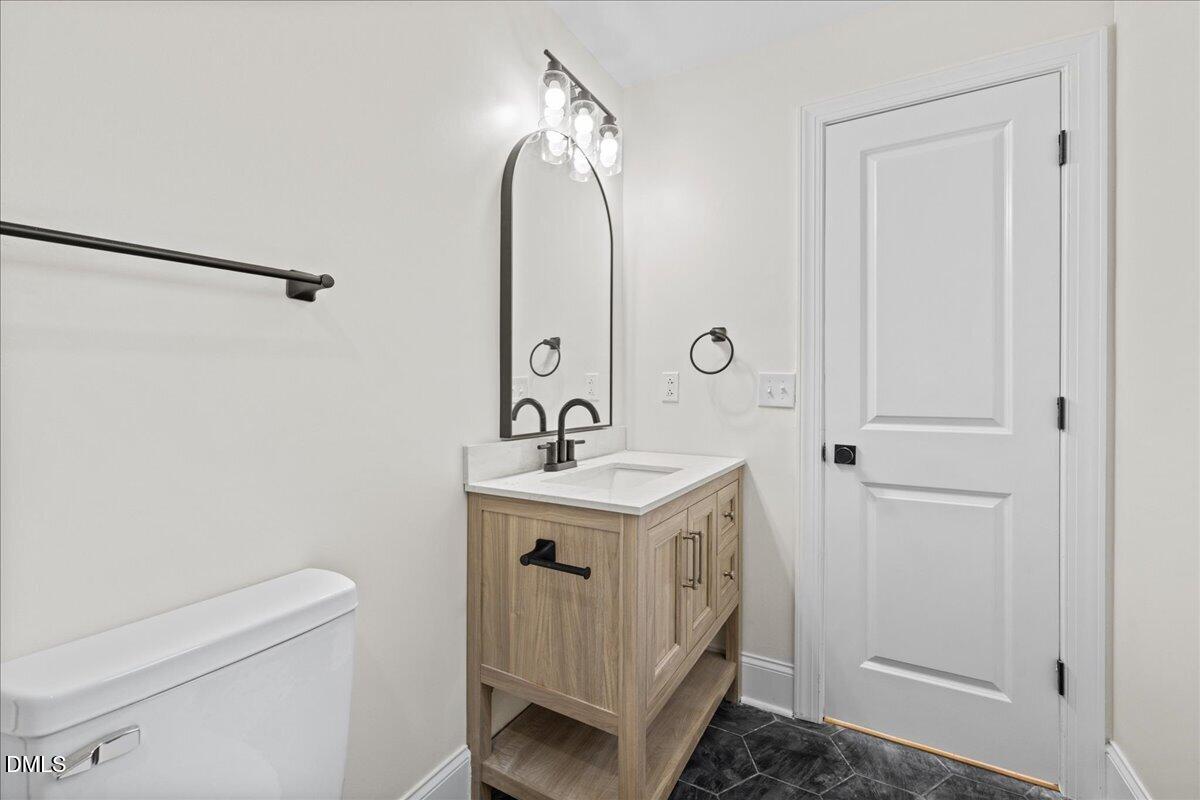 598 Bentonville Road Four Oaks, NC 27524 - Photo 30 of 40 a bathroom with a sink a toilet and a mirror