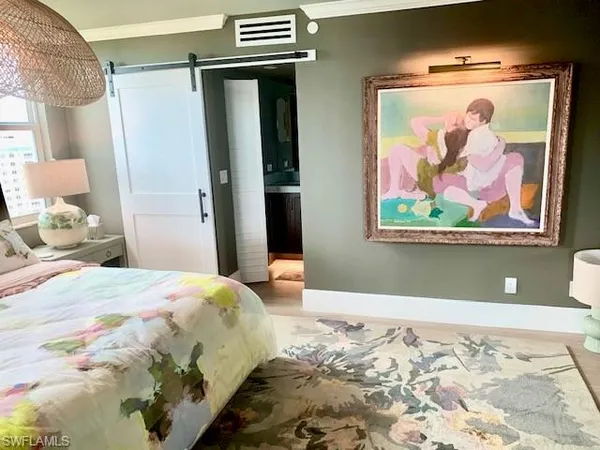 a bedroom with a bed and painting on the wall