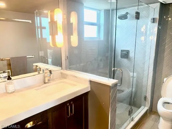 a bathroom with a sink and mirror with toilet
