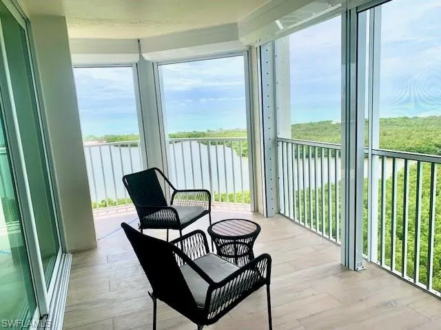 a balcony with couple of chairs and a swing