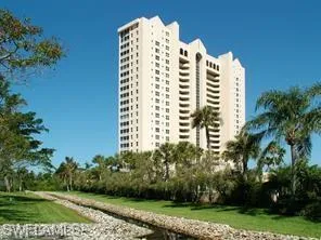 a view of a building with a yard and plants