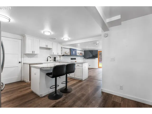 a kitchen with a sink cabinets and wooden floor