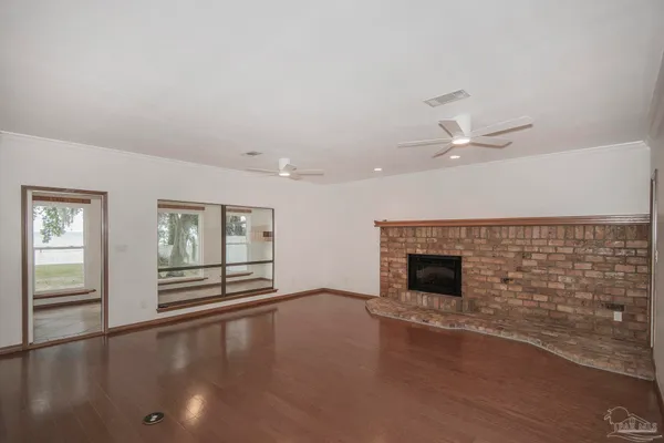 an empty room with windows and fireplace