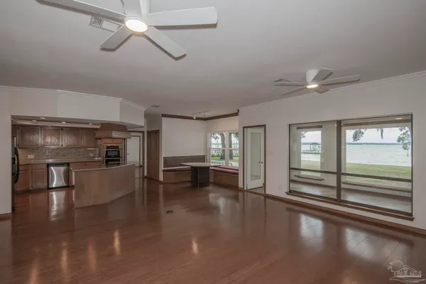 a view of a room with a large window and wooden floor
