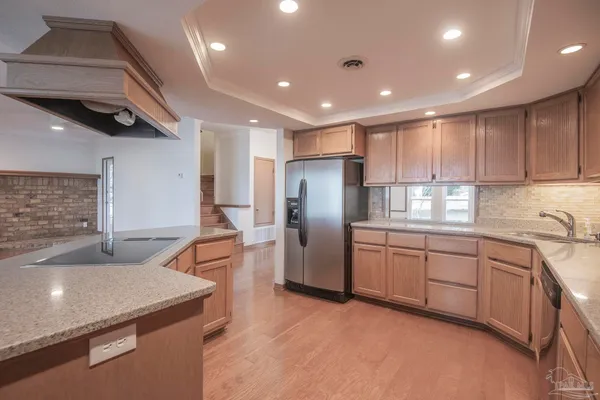 a kitchen with stainless steel appliances granite countertop a refrigerator a sink and a stove