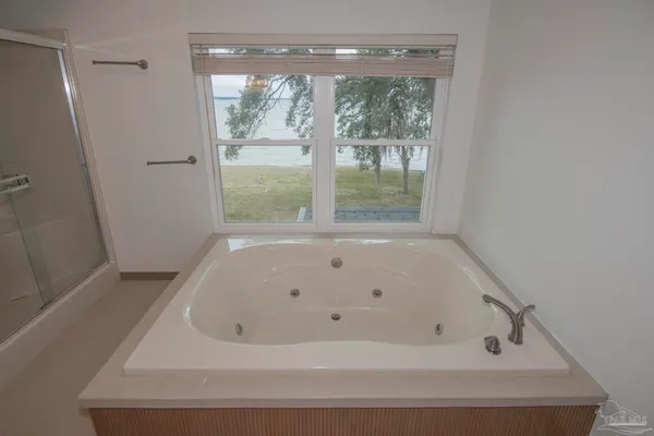 a bathroom with a tub sink and mirror