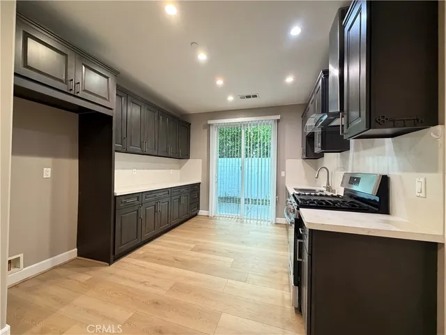 a kitchen with stainless steel appliances granite countertop a sink a stove and a refrigerator