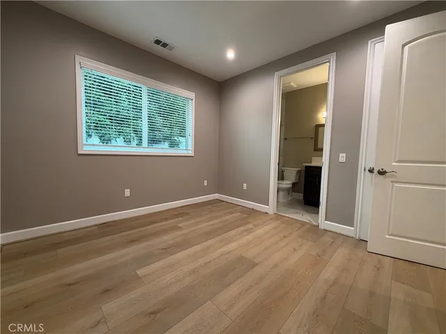 an empty room with wooden floor and a window