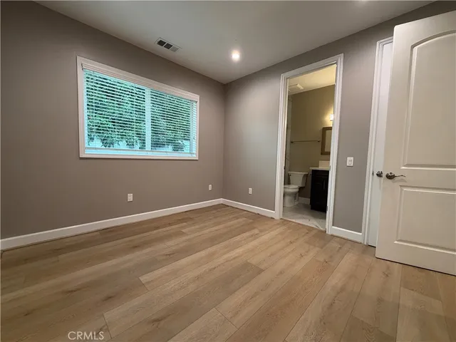 an empty room with wooden floor and a window