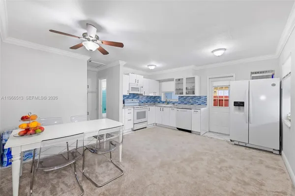 a living room with stainless steel appliances furniture and a chandelier