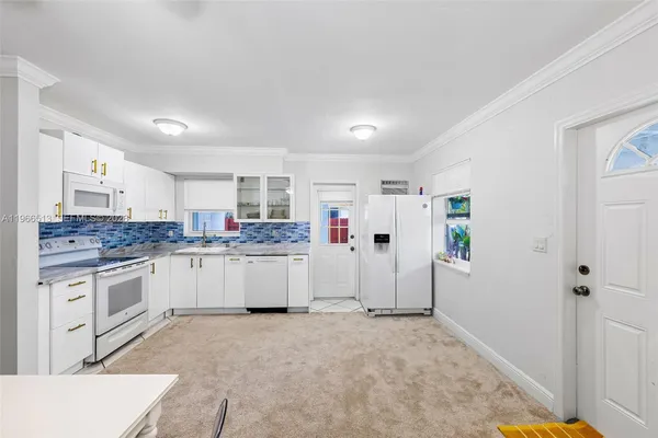 a kitchen with granite countertop white cabinets and white appliances