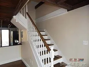 a view of staircase with lots of frames on wall and a window