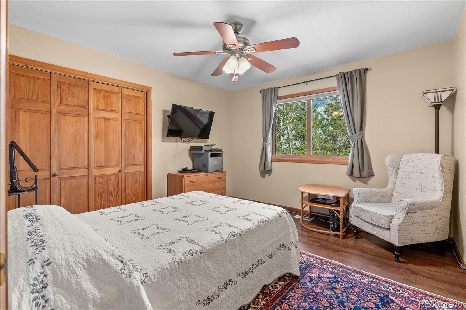 29 Cedar Lane Bailey, CO 80421 - Photo 17 of 46 a bedroom with a bed a couch and a flat tv screen on dresser