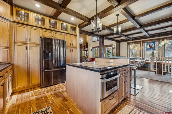 a kitchen with stainless steel appliances granite countertop a stove a refrigerator and a wooden cabinets